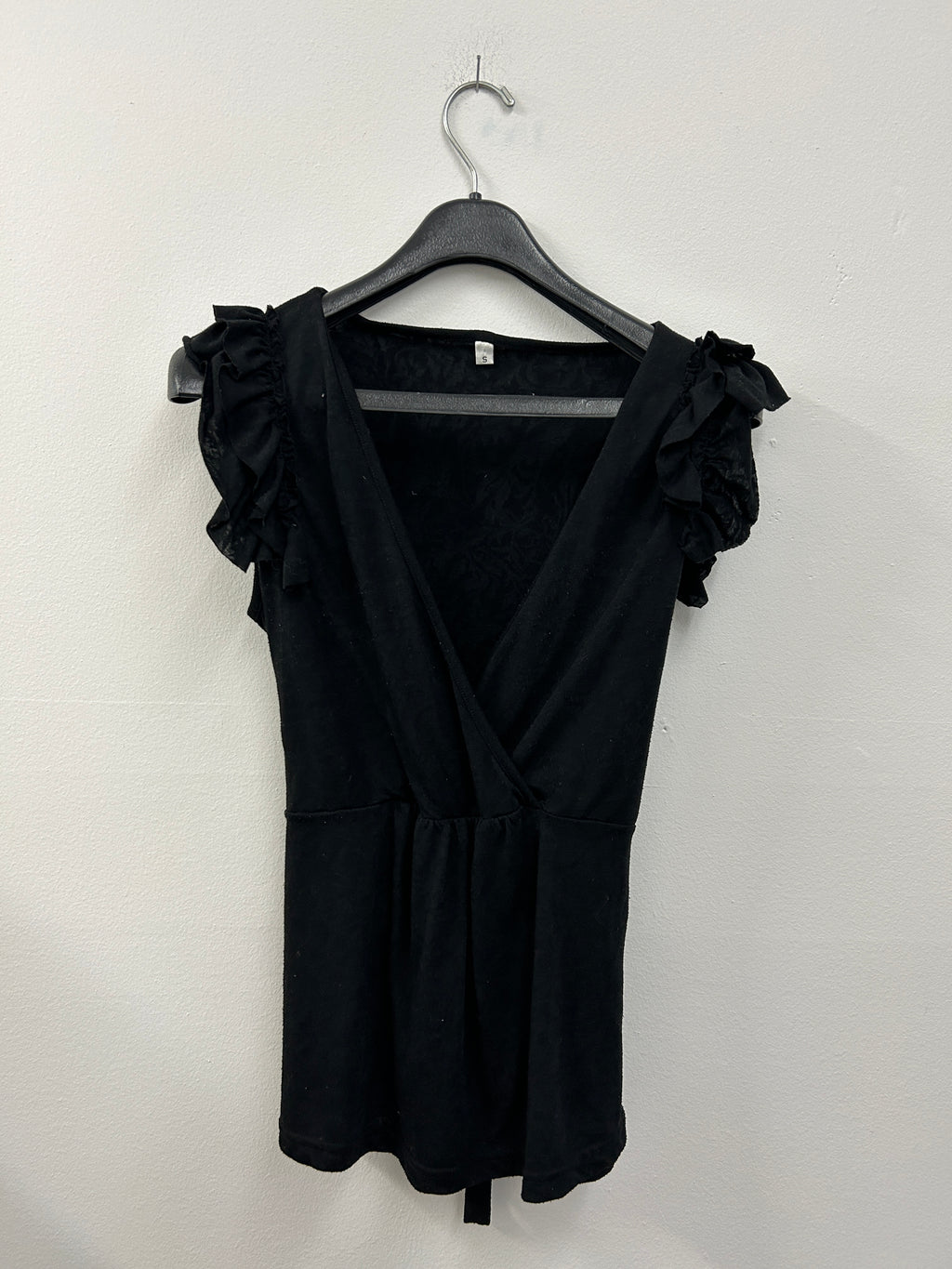 Haut cache-cœur noir à volants sur les épaules