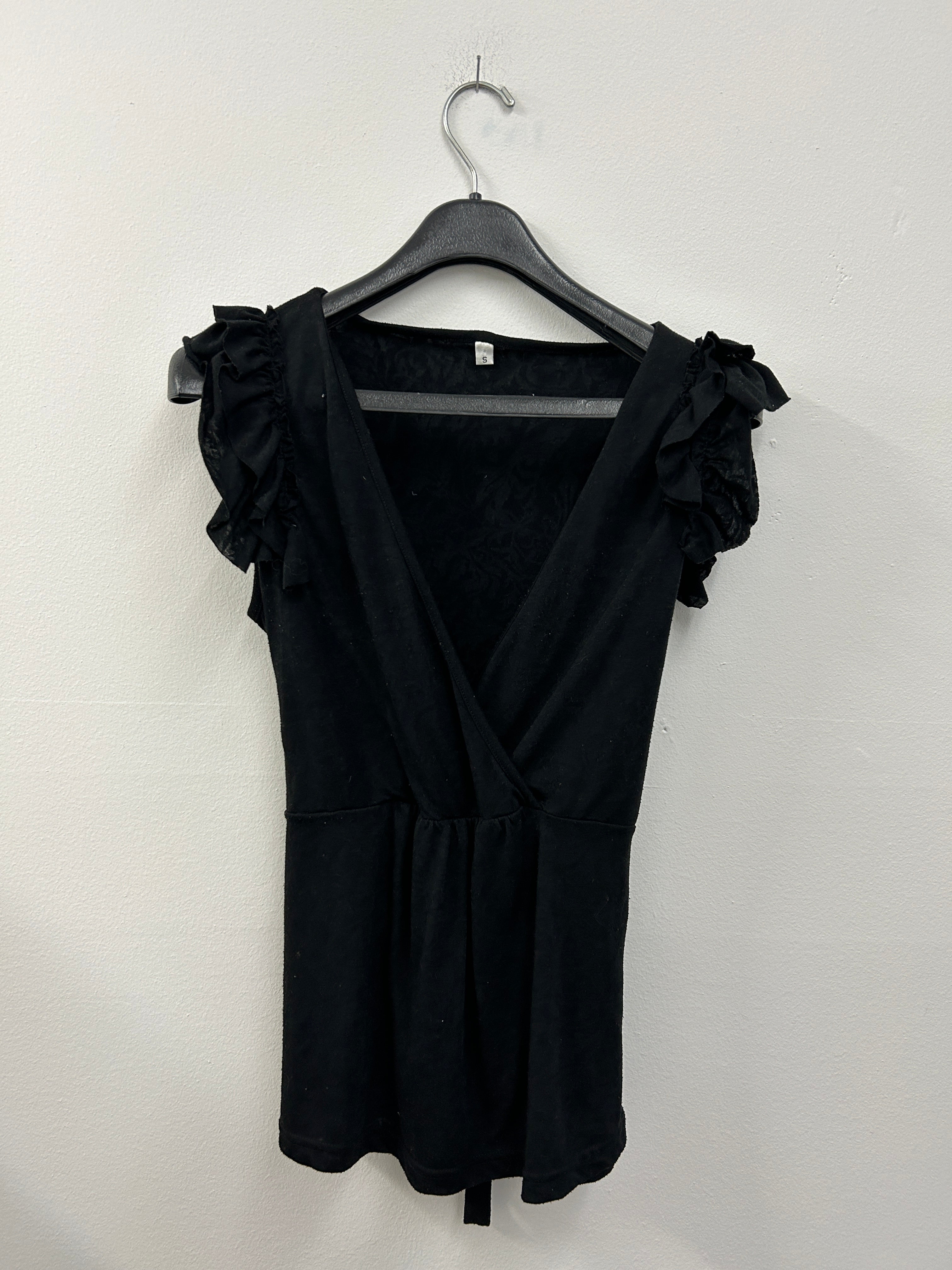 Haut cache-cœur noir à volants sur les épaules