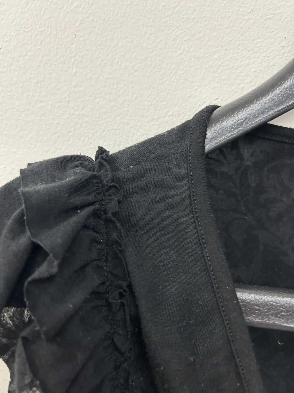 Haut cache-cœur noir à volants sur les épaules