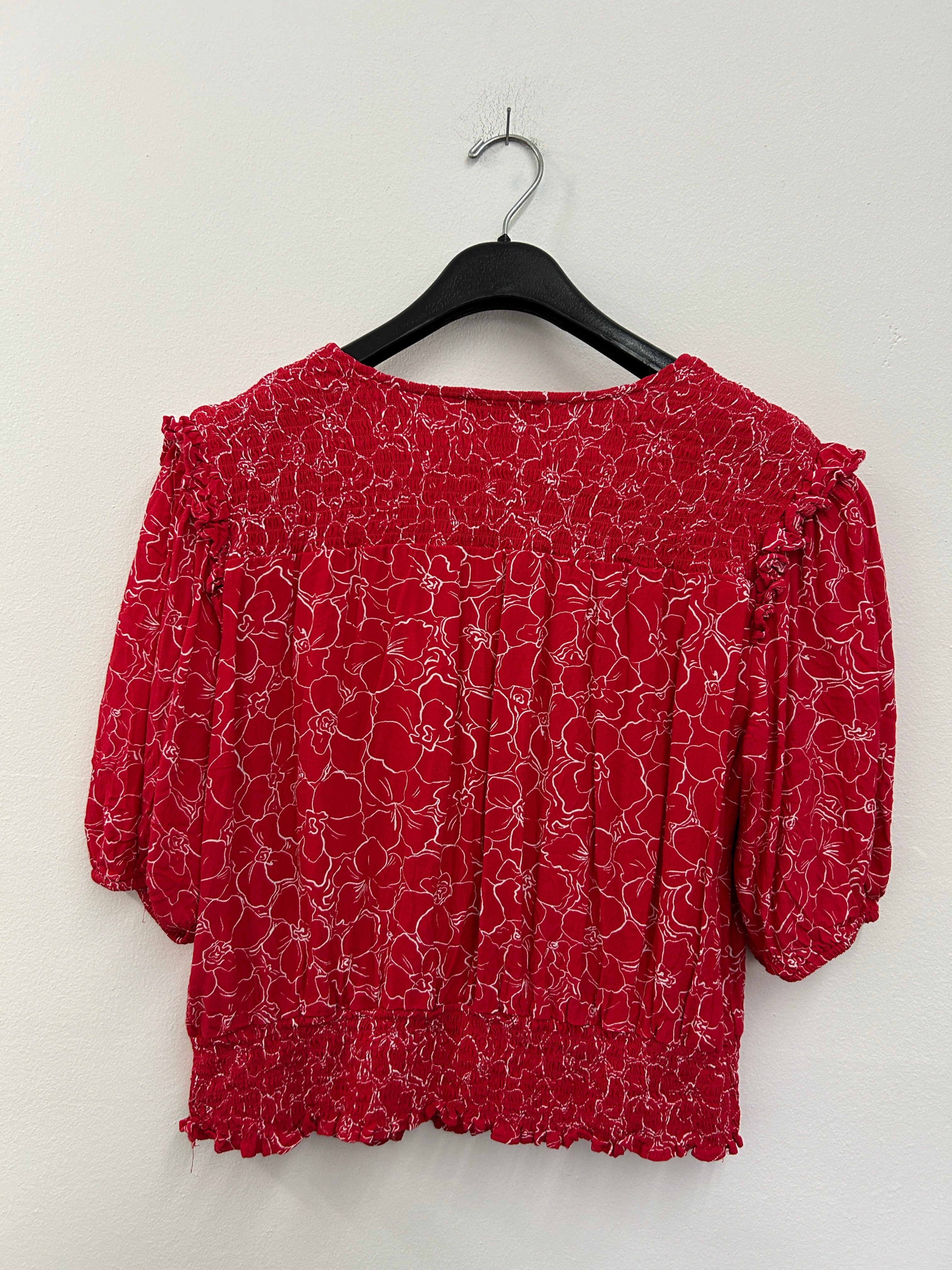 Haut rouge à fleurs croisées et taille froncée