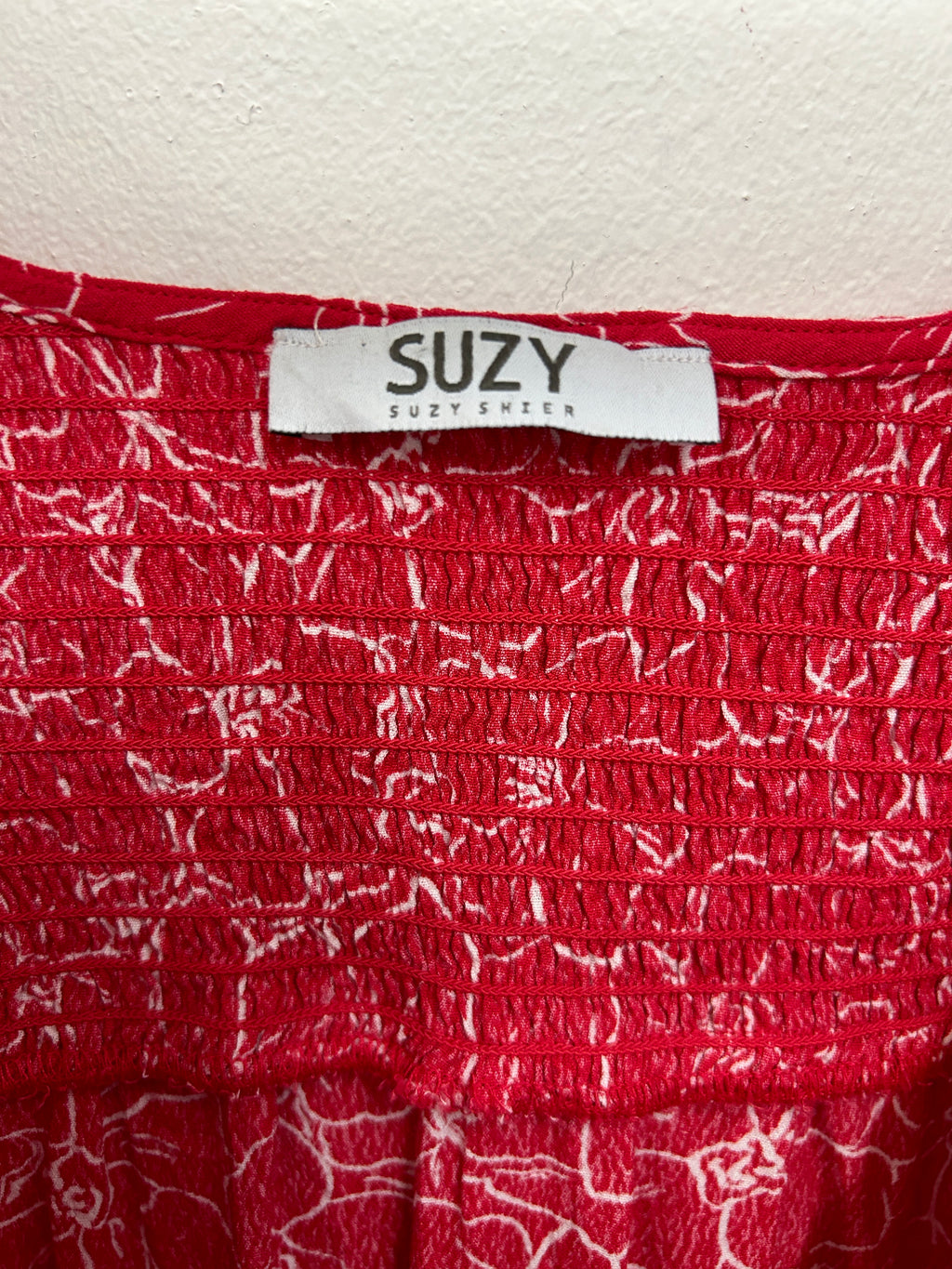 Haut rouge à fleurs croisées et taille froncée