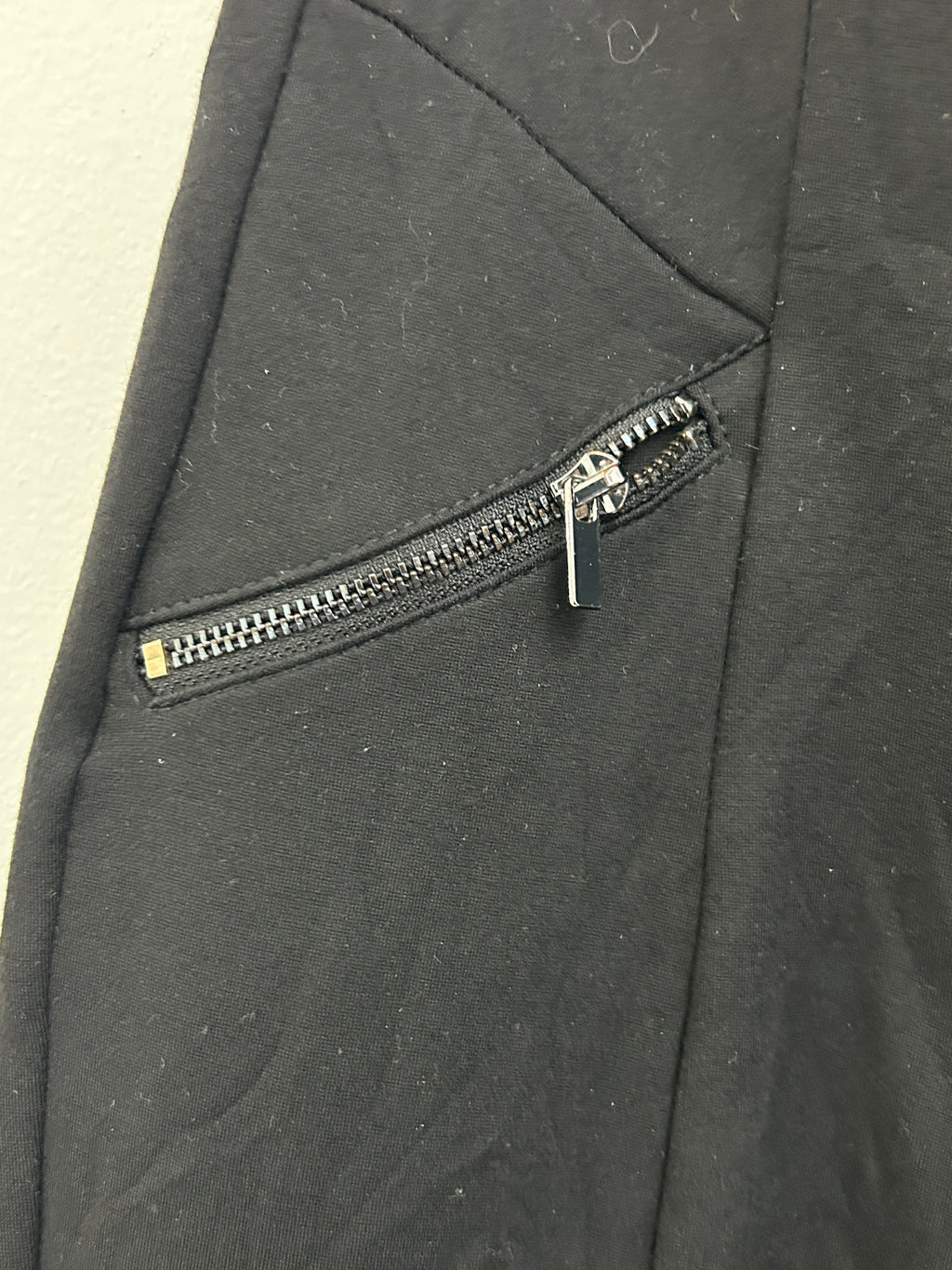 Pantalon noir ajusté à taille élastique et poches zippées