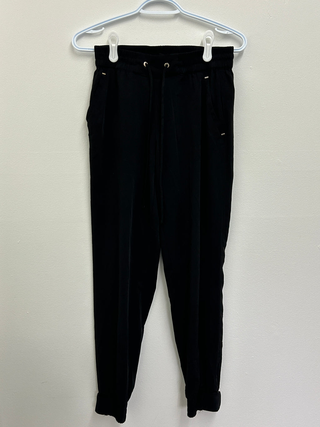 Pantalon noir ajusté à taille élastique et poches zippées